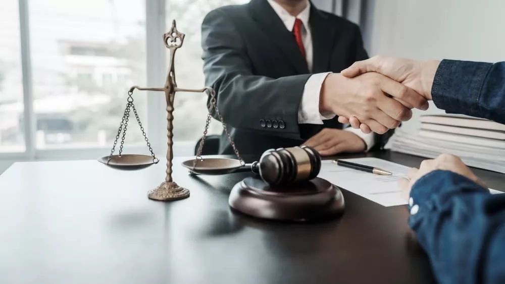 Lawyer and client engage in a conversation and finalizing the discussion with a handshake in Miami, FL.