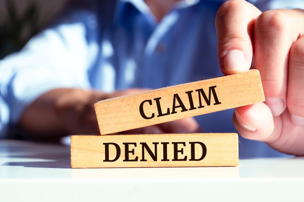Wooden blocks forming the phrase 'Claim denied