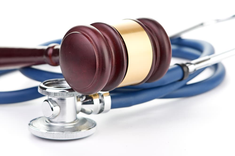 Brown gavel and a medical stethoscope on a table