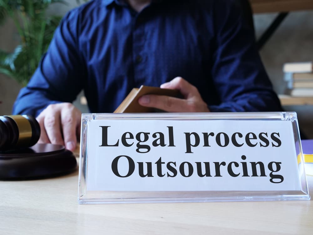 The concept of legal process outsourcing is depicted in the photo through displayed text.