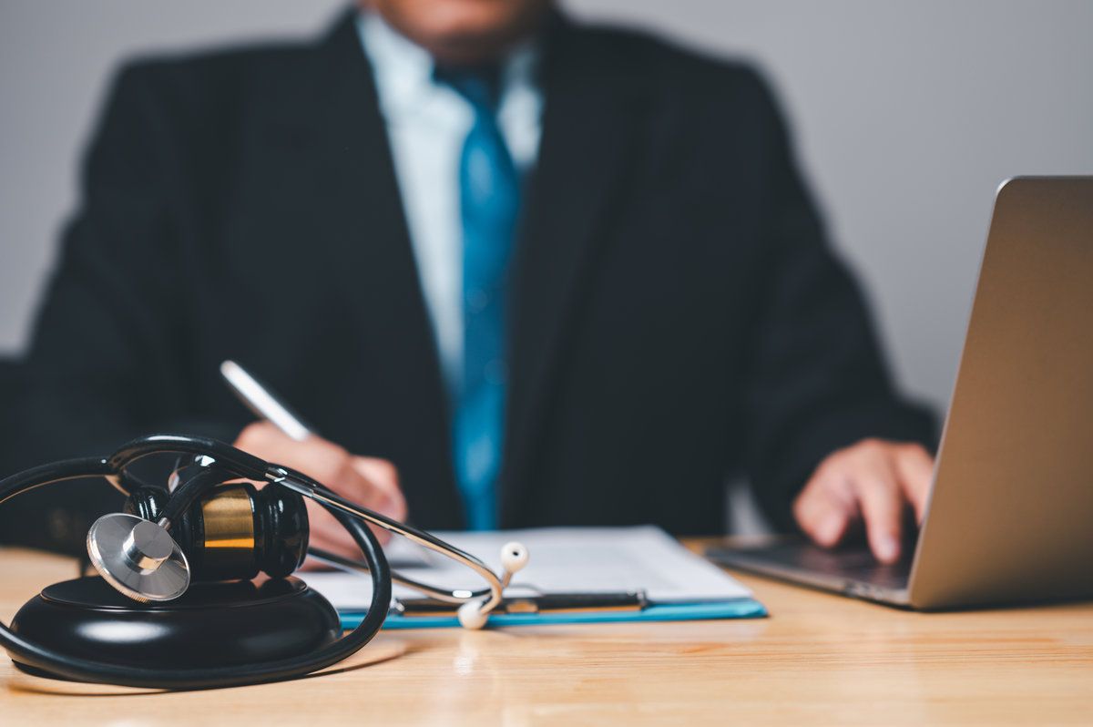 Lawyer reviewing legal documents with a stethoscope and laptop