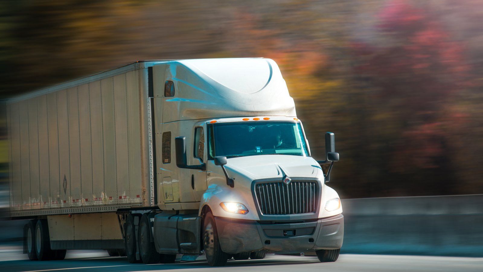 Semi truck with trailer on a highway, representing a truck at risk of an hours-of-service violation
